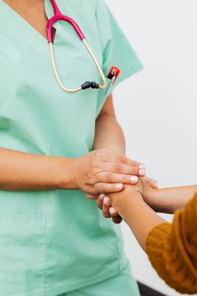 Crafting Captivating Headlines: Your awesome post title goes here A nurse in green scrubs gently clasps a patient's hand, offering support.